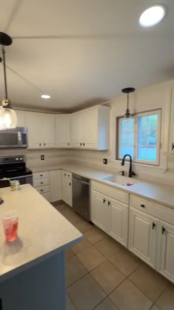 A finished kitchen with white cabinetry, a contrasting island and close finish detail.